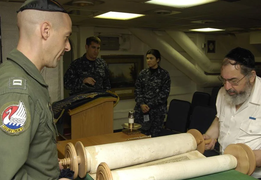 Meyer Malka, un rabbin militaire français, ouvre la Torah pendant un office célébré à bord du porte-avions USS Harry S. Truman