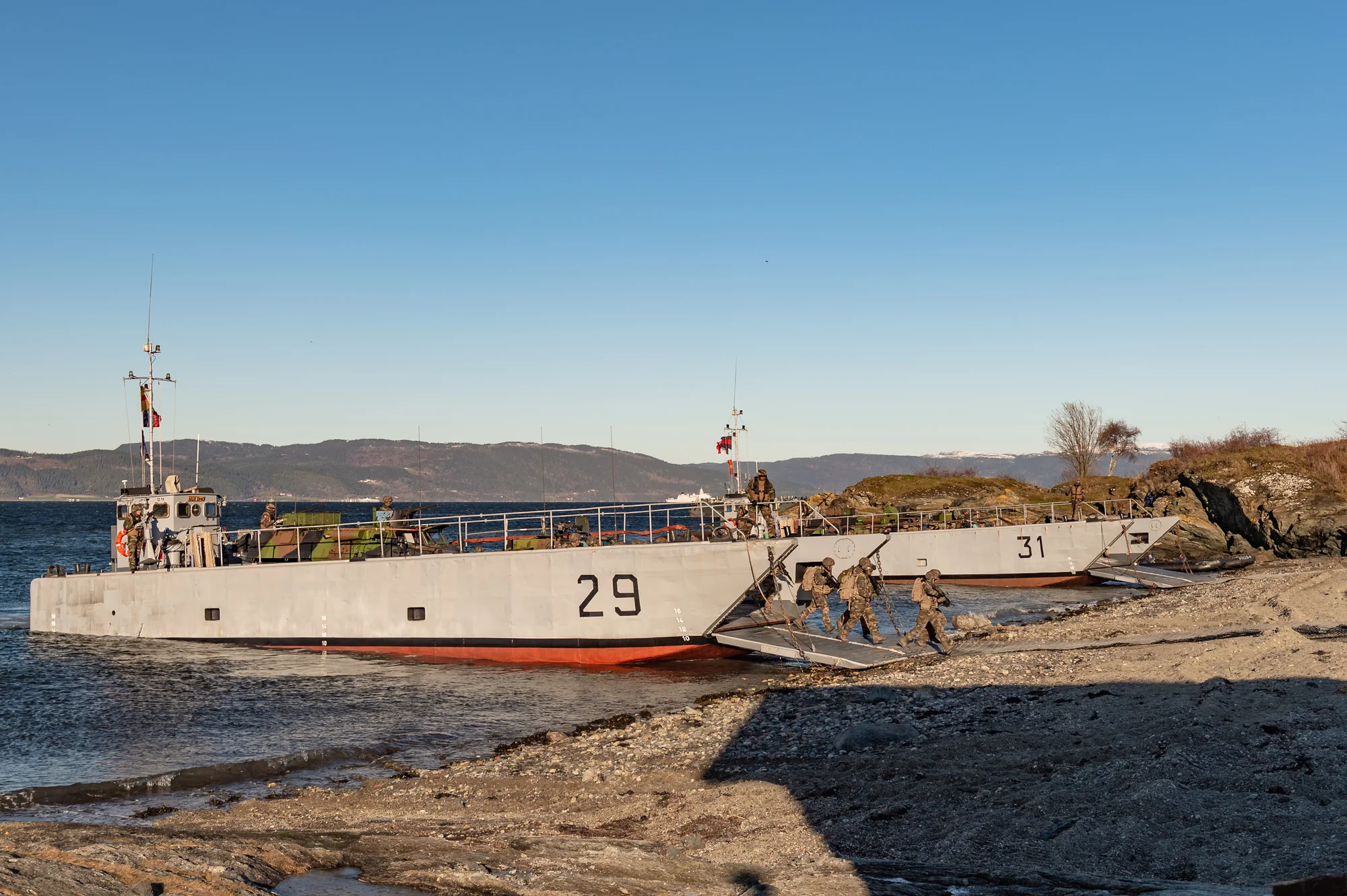 Des soldats débarquent d'un chaland de transport de matériel