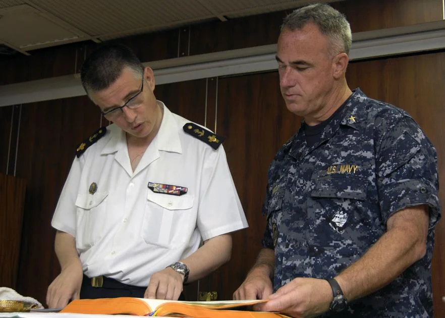 Pascal Frey, à gauche, lit les Ecritures avec le chapelain américain Tom Ianucci avant de célébrer une messe commune catholique à bord du porte-avions américain USS Harry S. Truman