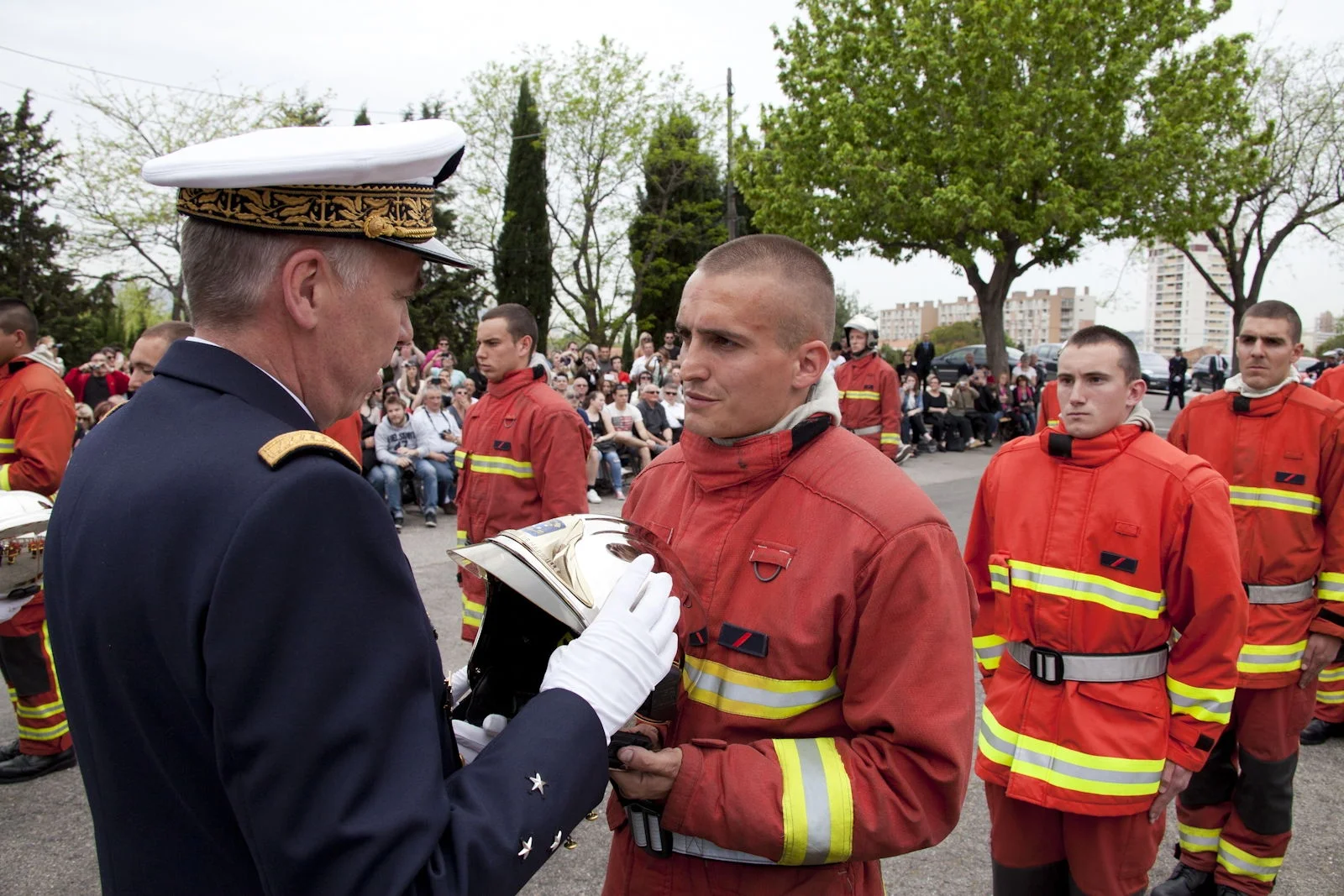 Un nouveau marin-pompier reçoit son casque des mains du vice-amiral L’Hénaf