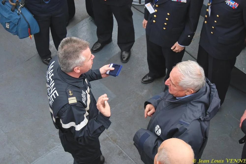 Le commandant actuel remet à un de ses prédécesseurs une médaille et une casquette