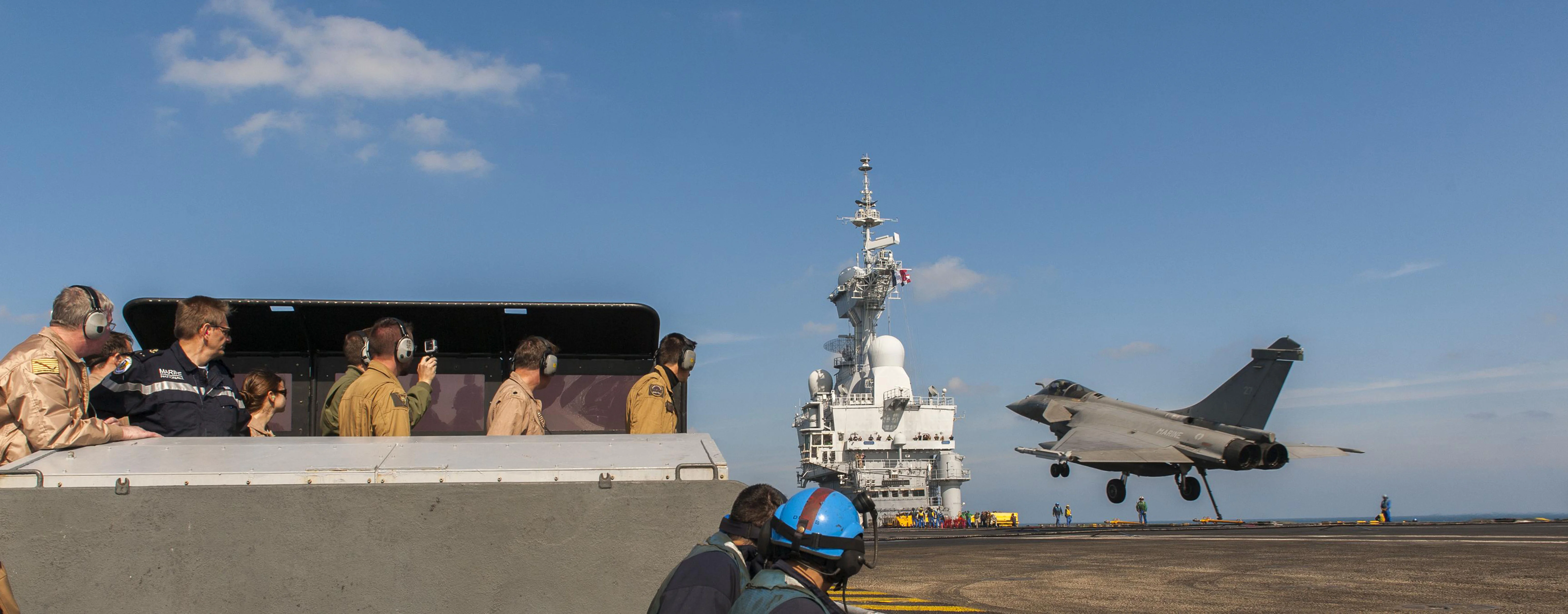 Le vice-amiral John Miller (à gauche) et le contre-amiral Eric Chaperon (2è à gauche) assistent à l'appontage d'un Rafale sur le Charles de Gaulle
