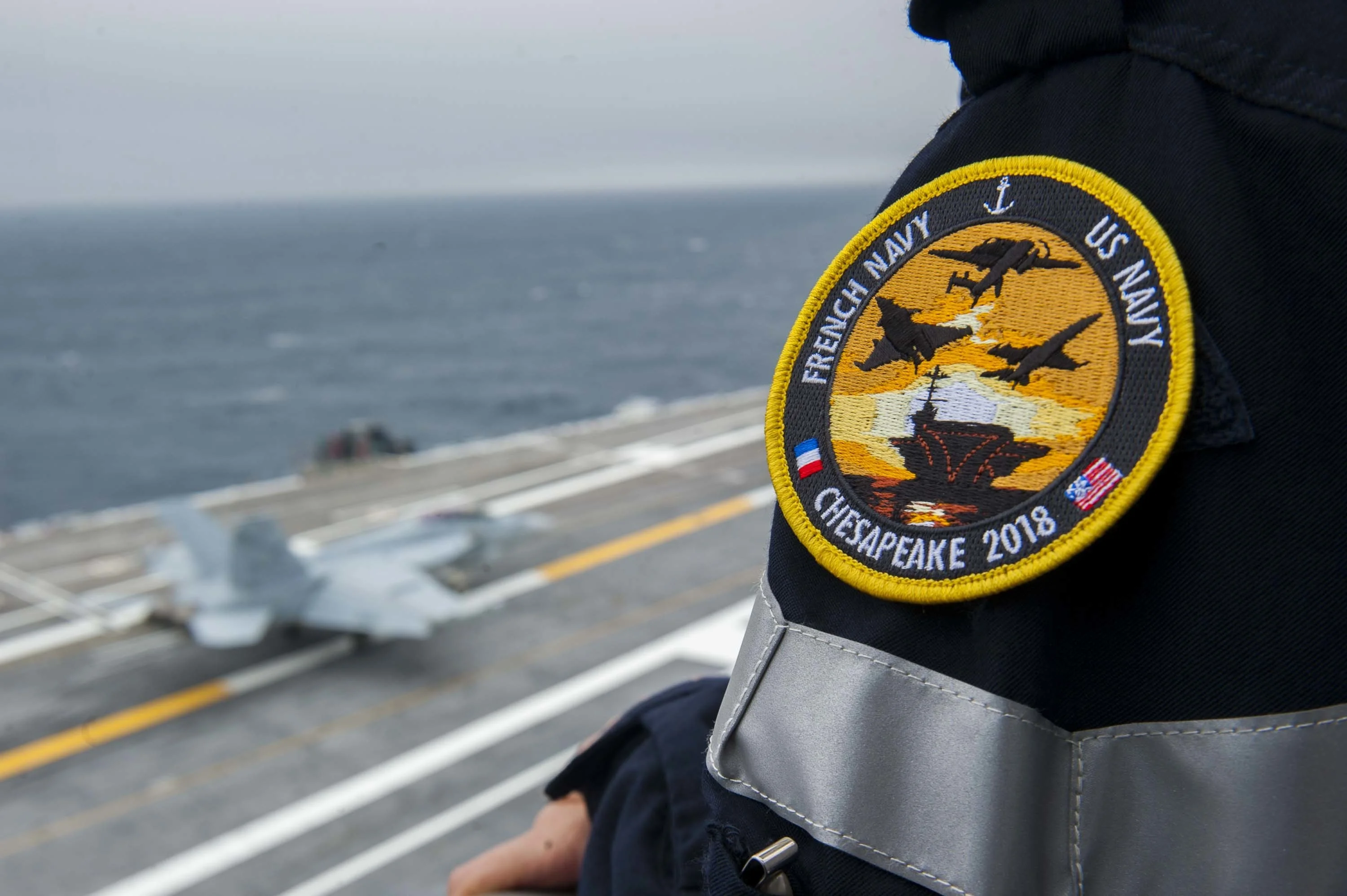 Un marin français assiste aux manoeuvres sur le pont de l'USS George H.W. Bush