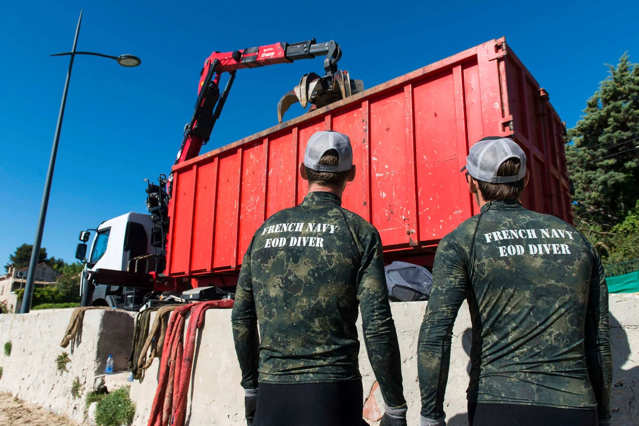 Les plongeurs démineurs surveillent le périmètre de sécurité lors de l'opération de levage de l'embarcation