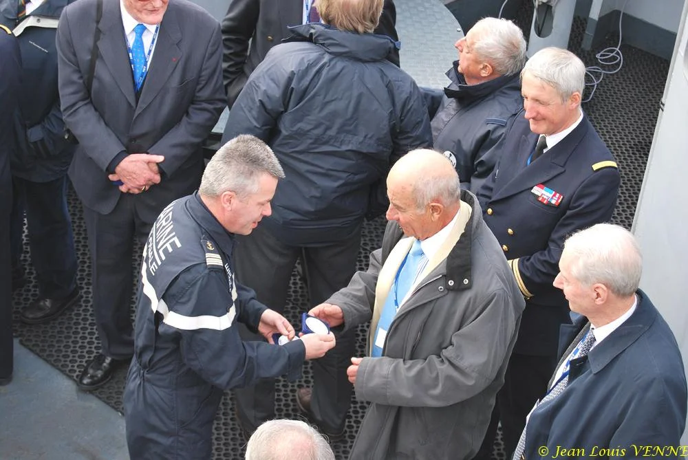 Le commandant actuel remet à un de ses prédécesseurs une médaille et une casquette