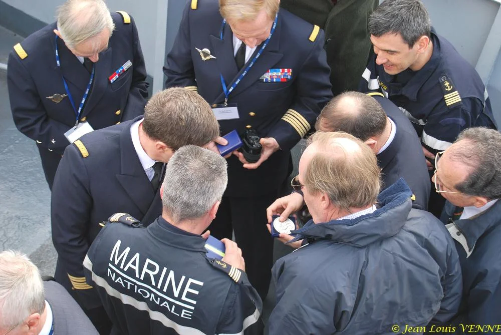 Le commandant actuel remet à un de ses prédécesseurs une médaille et une casquette