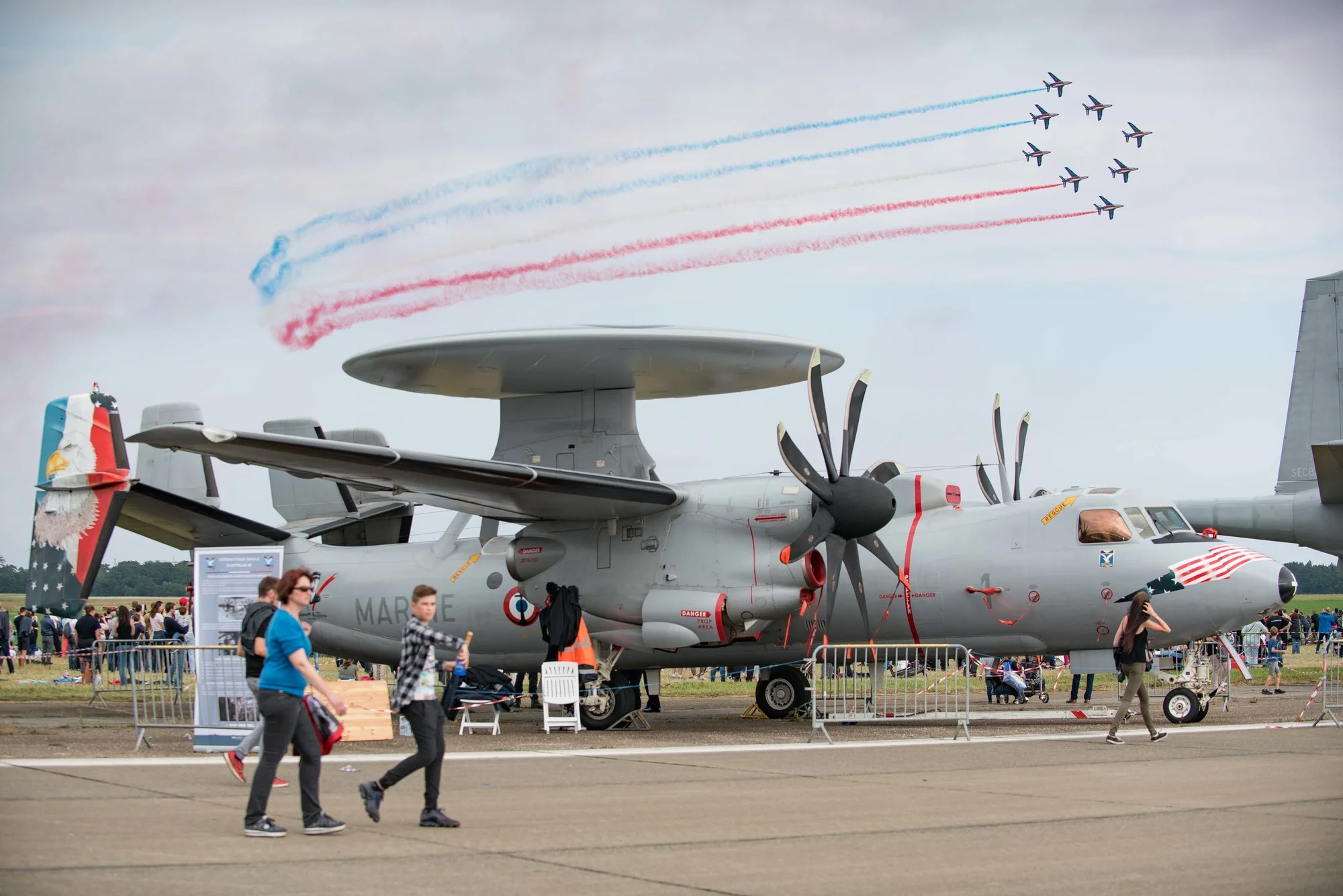 Un avion de guet aérien E2C - Hawkeye survolé par la patrouille de France