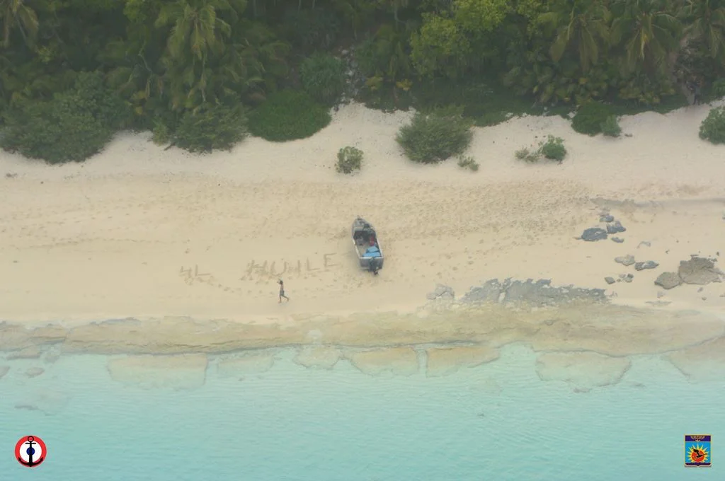 Appel au secours écrit sur le sable