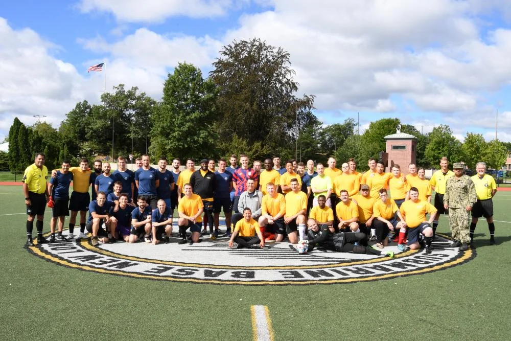 Des membres d'équipage de l'Améthyste, de l'USS Cheyenne et d'autres unités basées à Groton posent avant un match amical de football