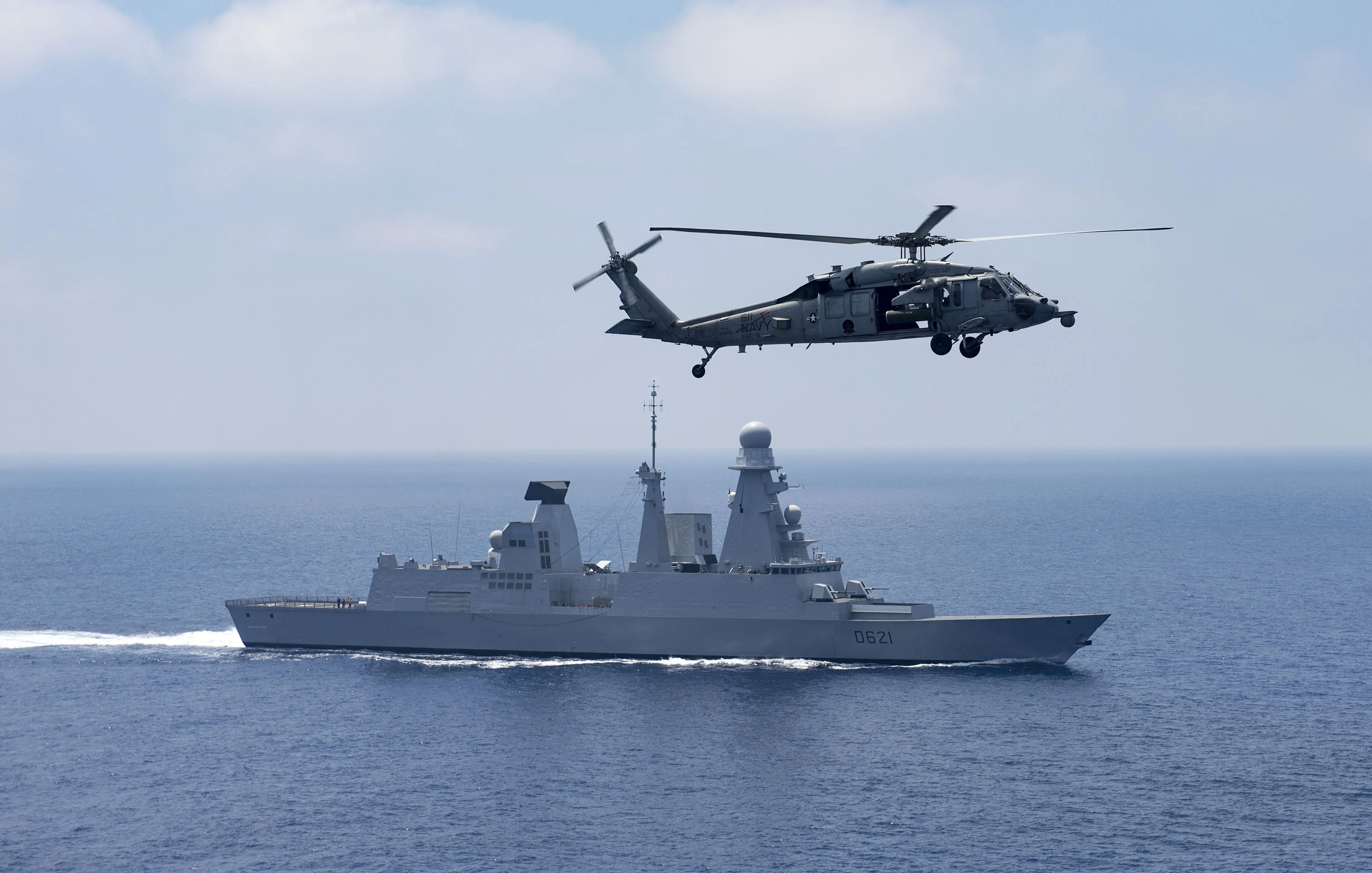 La frégate Chevalier Paul survolée par un hélicoptère MH-60S Sea Hawk Super embarqué sur le porte-avions USS George H.W. Bush