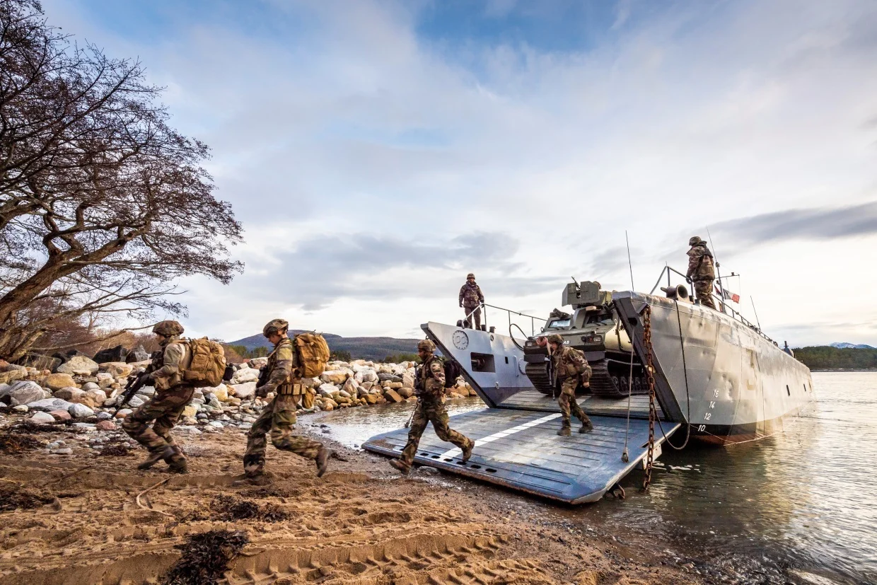 Des soldats débarquent d'un chaland de transport de matériel