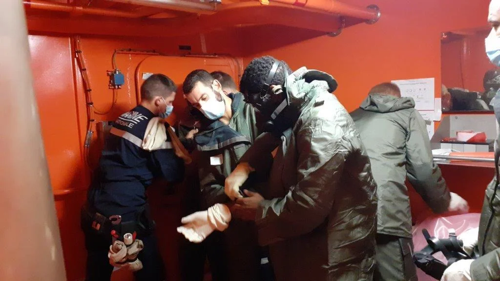 Un membre de l'équipage du Forbin s'équipe d'une combinaison NRBC (Nucléaires, radiologiques, biologiques et chimiques)