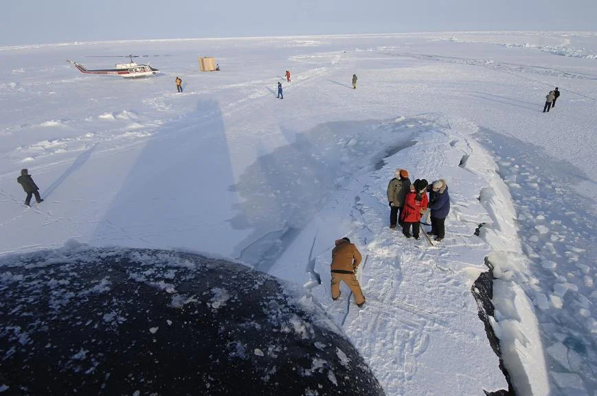 Des marins enlèvent la glace du panneau d'embarquement du SNA USS Alexandria