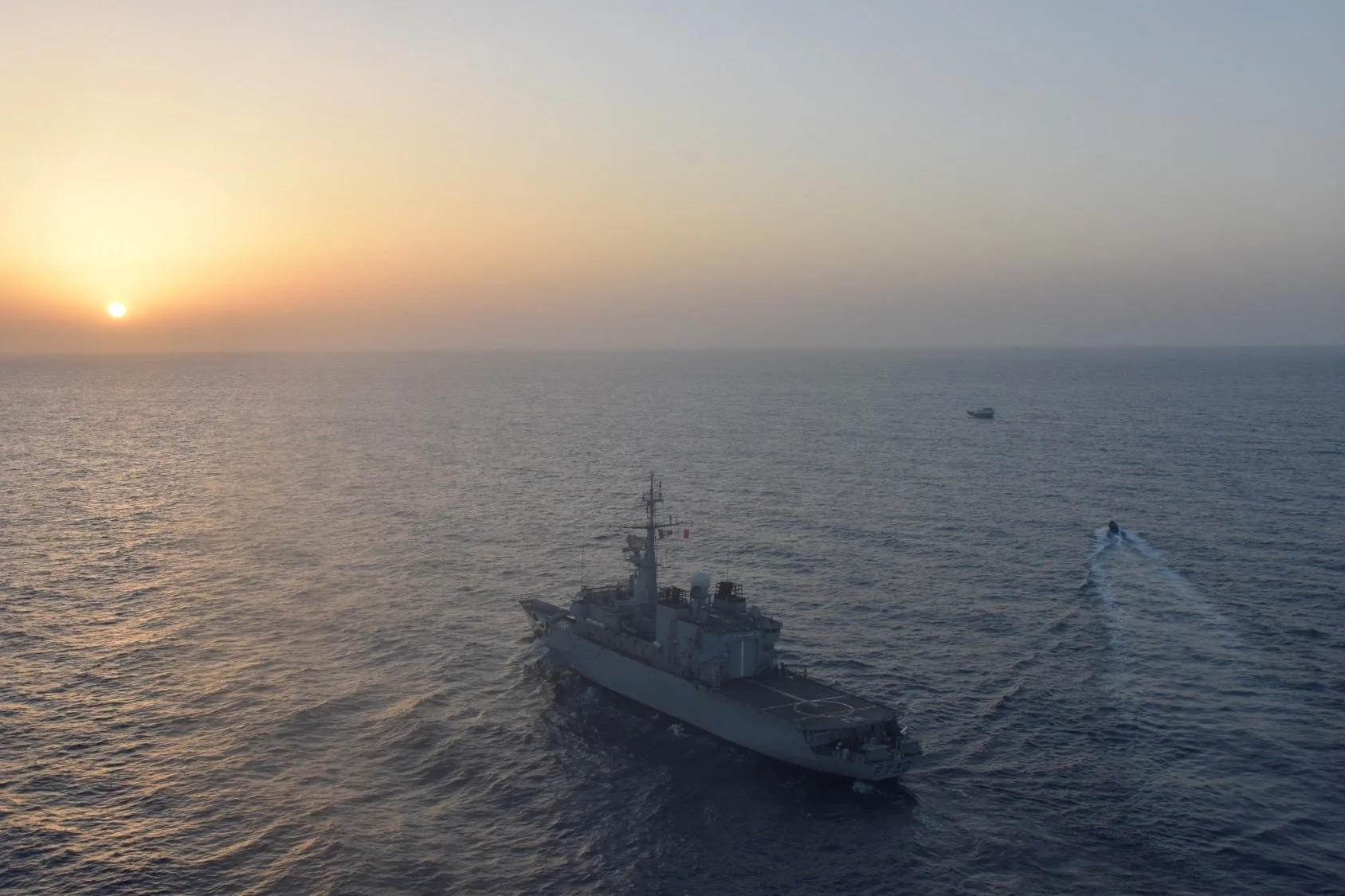 Une frégate de surveillance, dont l'équipe de visite va inspecter un boutre suspect